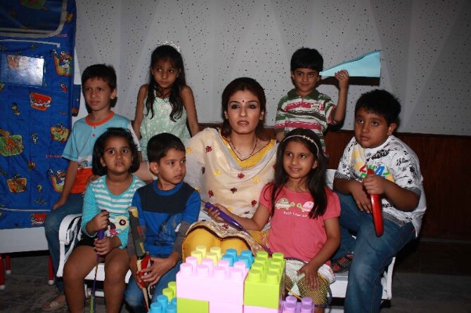 Raveena Tandon posing with school children celebrating Childrens Day in